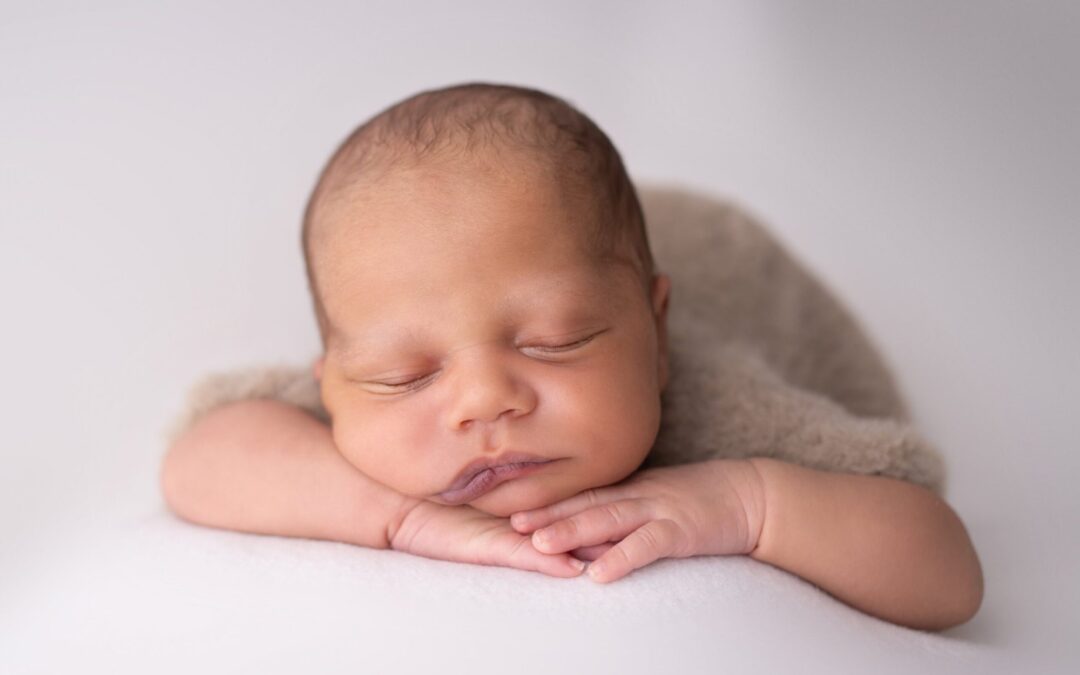 Séance photo nouveau-né à Serris : bébé endormi, le menton posé sur ses mains